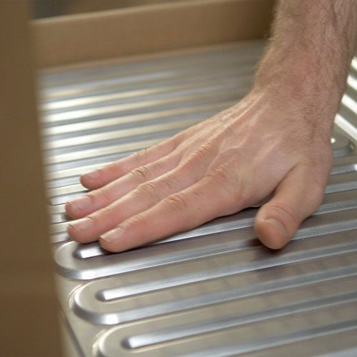 Eine Hand streicht über die hochwertige Oberfläche von unserem Edelstahl Wärmetauscher.